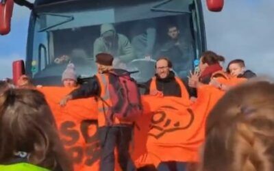 Climate protesters throw themselves in front of bus full of migrants