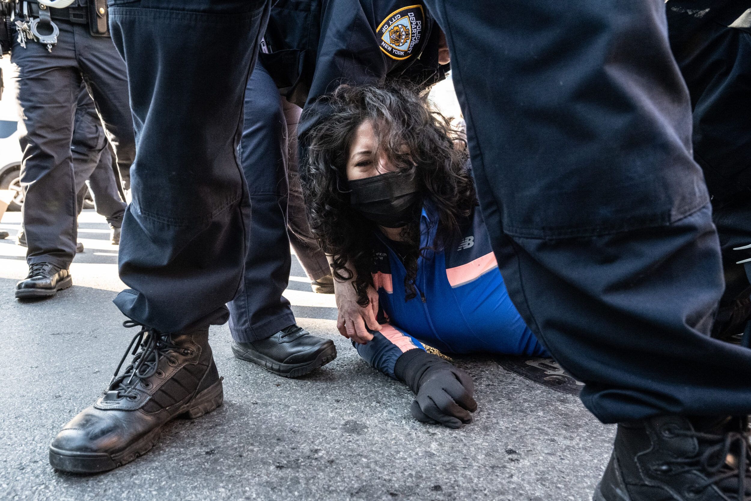 NEW YORK, NEW YORK - NOVEMBER 29: A person is detained by NYPD as immigration activists block ICE vans during a protest against a purported ICE raid on Canal Street on November 29, 2025 in New York City. Activists assembled outside of a garage used by ICE and later they tried to block ICE vehicles as they traveled from the garage down Canal Street to the Holland Tunnel to exit Manhattan. (Photo by Stephanie Keith/Getty Images)