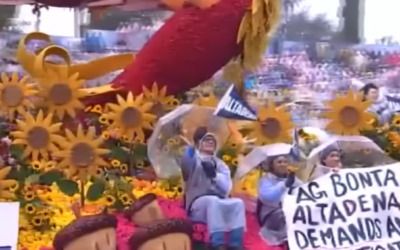 Raincoat-clad bootlicker pulls down Rose Parade sign demanding accountability for deadly wildfires